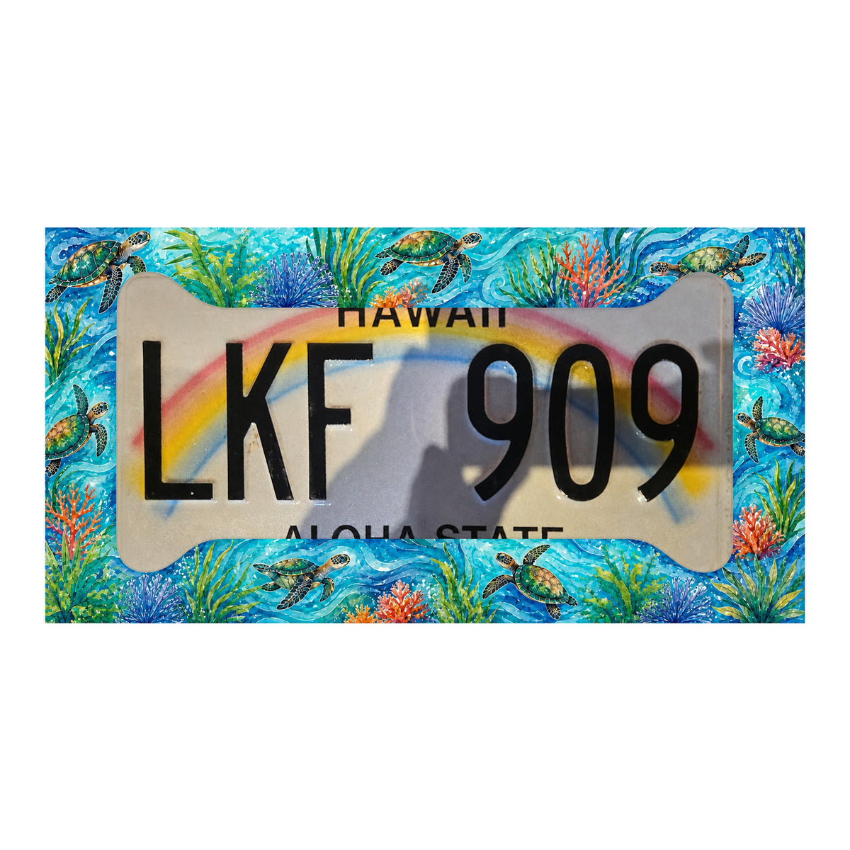 Illustrative mockup of the turquoise sea turtle and coral frame over a Hawaii rainbow license plate; plate not included.