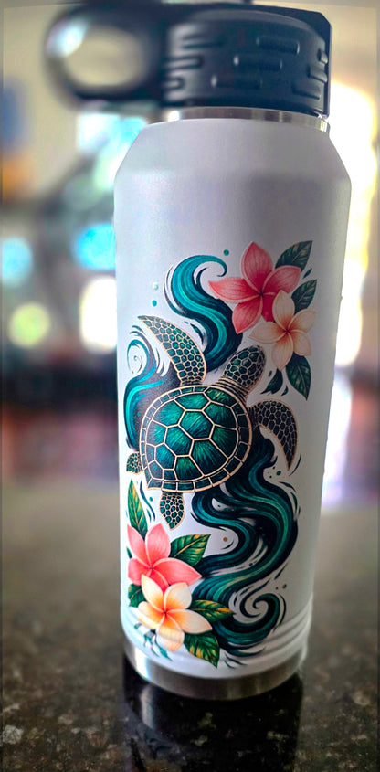 White 32 oz insulated water bottle with green sea turtle, teal ocean waves, and pink and cream plumeria flowers, black flip-top straw lid