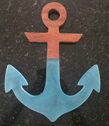 Mahogany and translucent ocean-blue resin anchor on a dark stone background