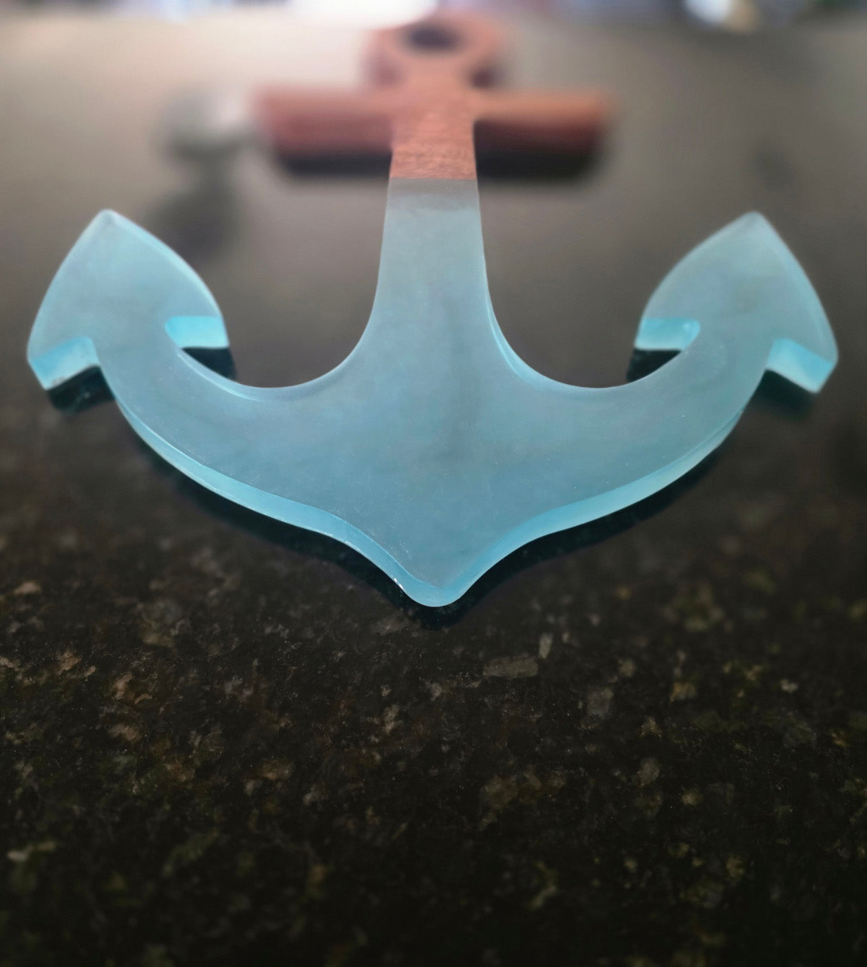 Close-up of translucent blue resin anchor points and the mahogany-to-resin transition