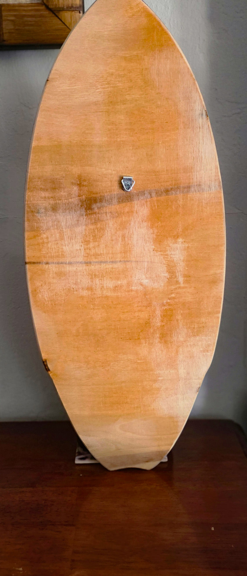 Natural wood back of the plumeria surfboard wall art with a sawtooth hanger, ready to hang