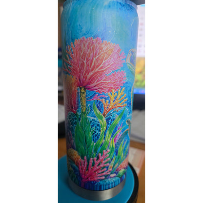 Close view of the bottle wrap showing bright pink coral, green sea plants, and blue ocean artwork.