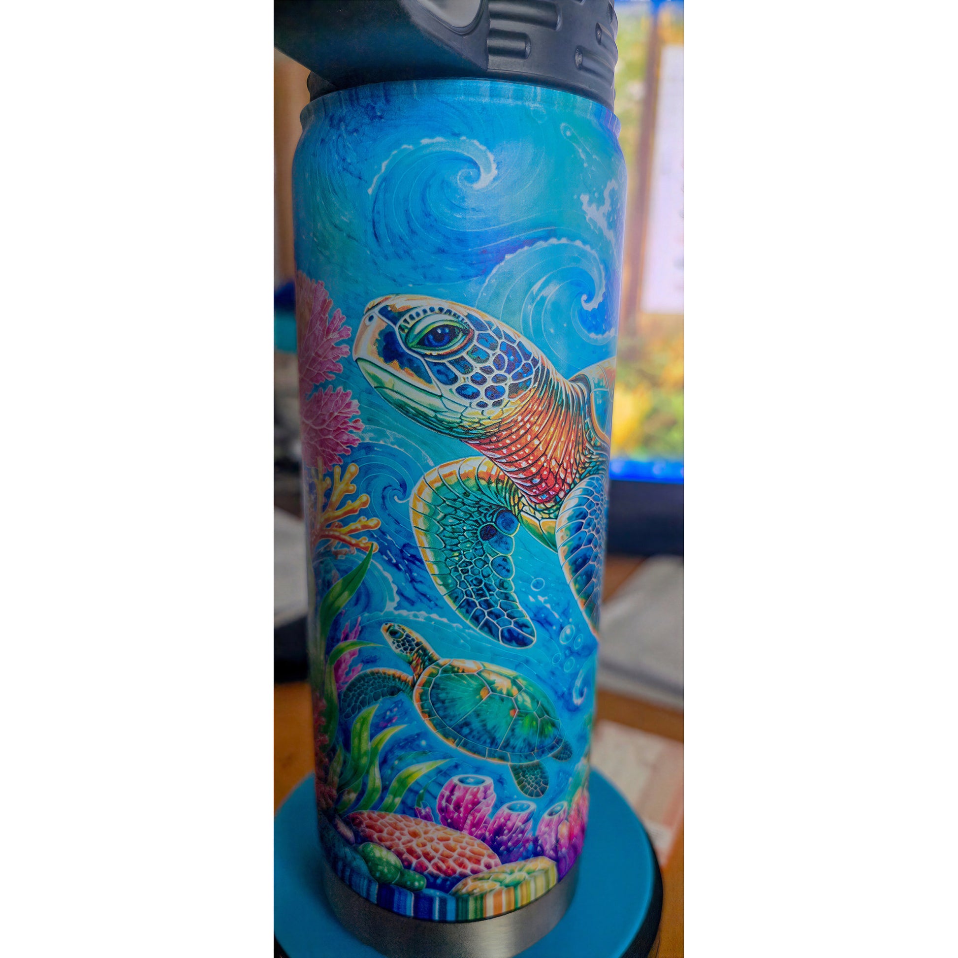 Close view of a large Hawaiian honu and smaller sea turtle on the blue ocean bottle design.
