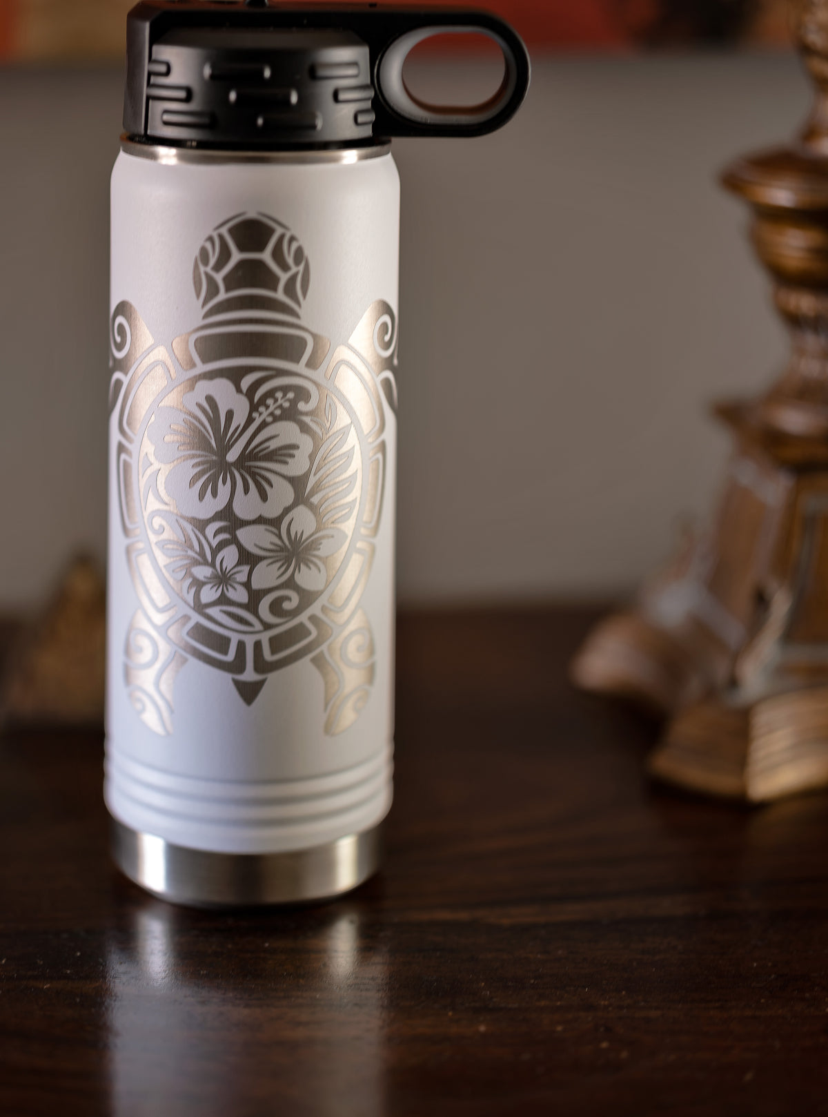 White engraved sea turtle water bottle with hibiscus design on a wood table — primary product photo | Beach Hut Decor