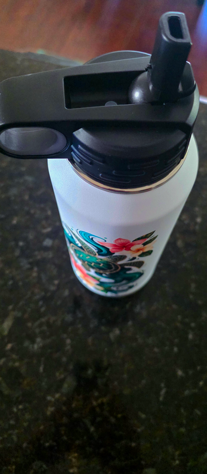 Top view of the black flip-top lid with built-in straw spout and carry loop, turtle artwork visible below