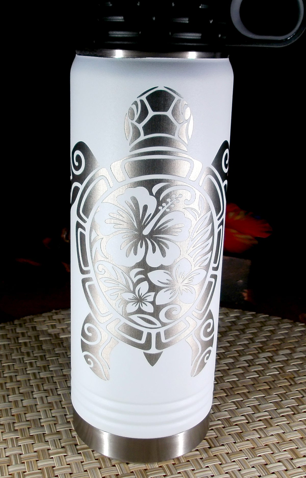 Full front view of the white 20 oz bottle showing the silver floral sea turtle engraving and black flip-top lid.