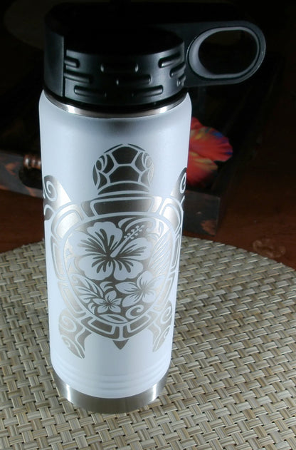 Angled top view of the white engraved sea turtle bottle showing the black carry-loop lid and silver floral honu design.